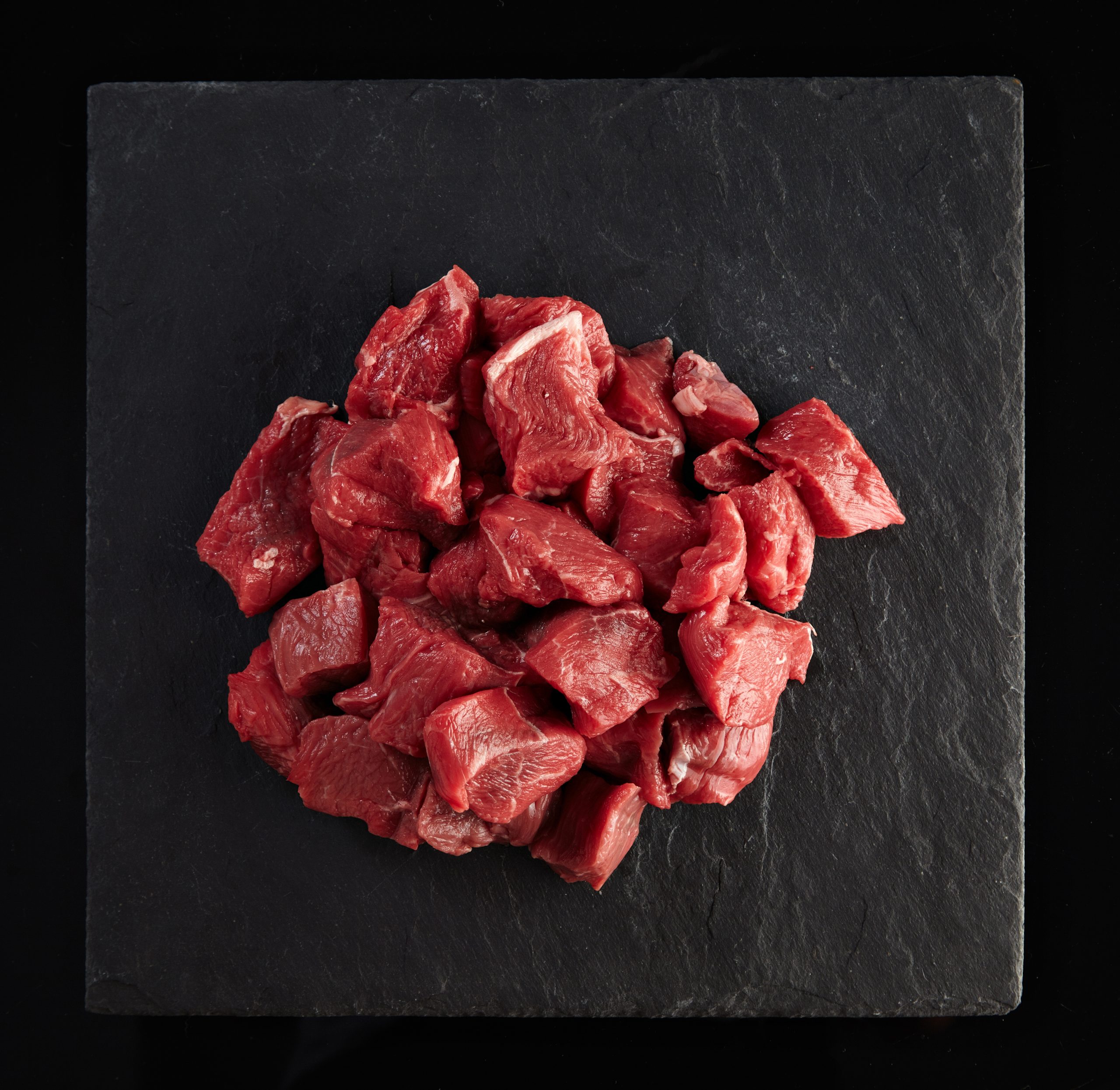 Meat slice isolated on black cooking set Pieces of raw fresh meat isolated on black on stone board, top view